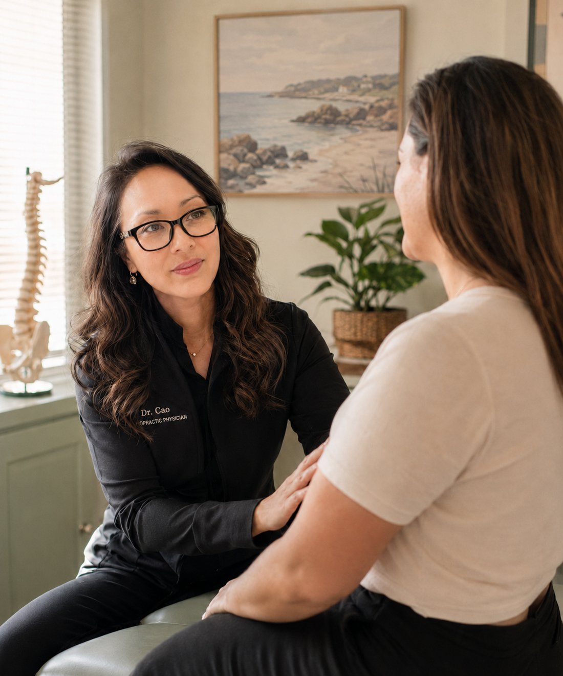 Dr. Kelly Cao consulting with a patient in the Healing Hands treatment room in Worcester